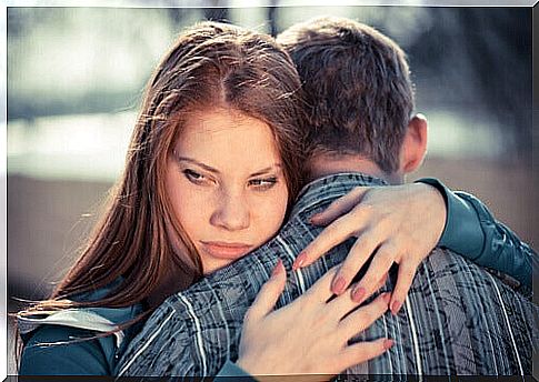 hugging couple and worried woman