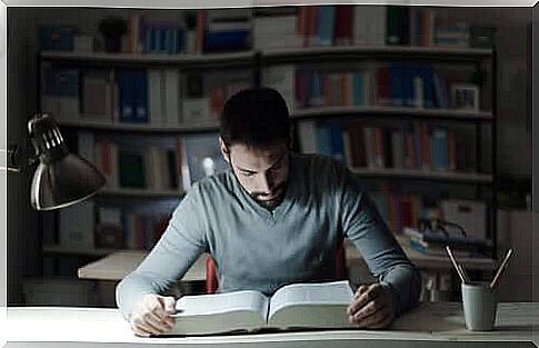 A boy student reading a book.